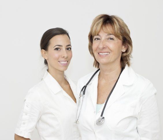 Two smiling dentists in white lab coats