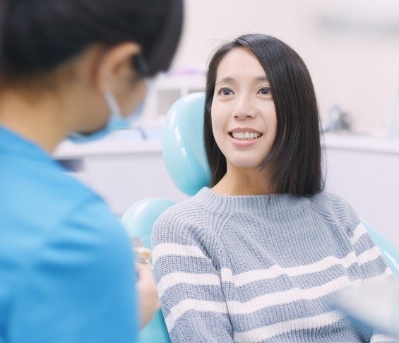 Woman in dental chair listening to her dentist