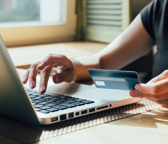 Person entering their credit card information on a laptop