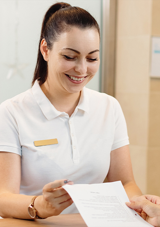 Dental team member showing paperwork to a patient in Paramus endodontic office