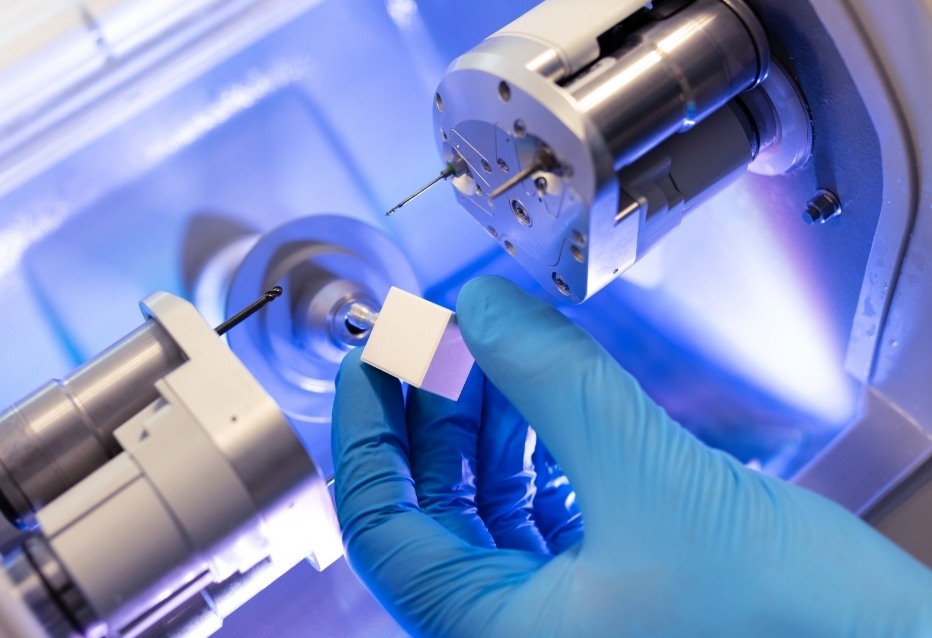 Dental professional placing block of ceramic into dental crown machine